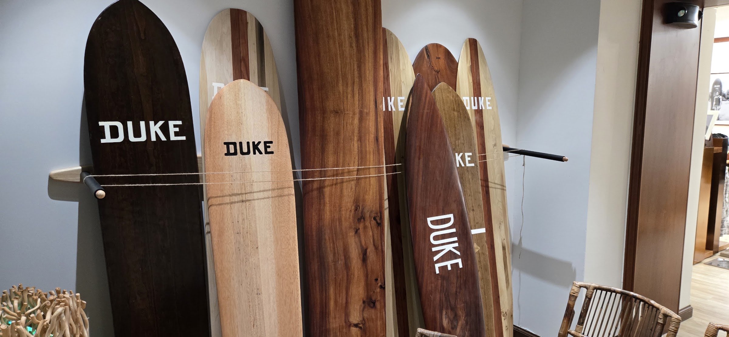 A close view of a row of wooden surfboards leaning side by side, showing the grain of the wood.